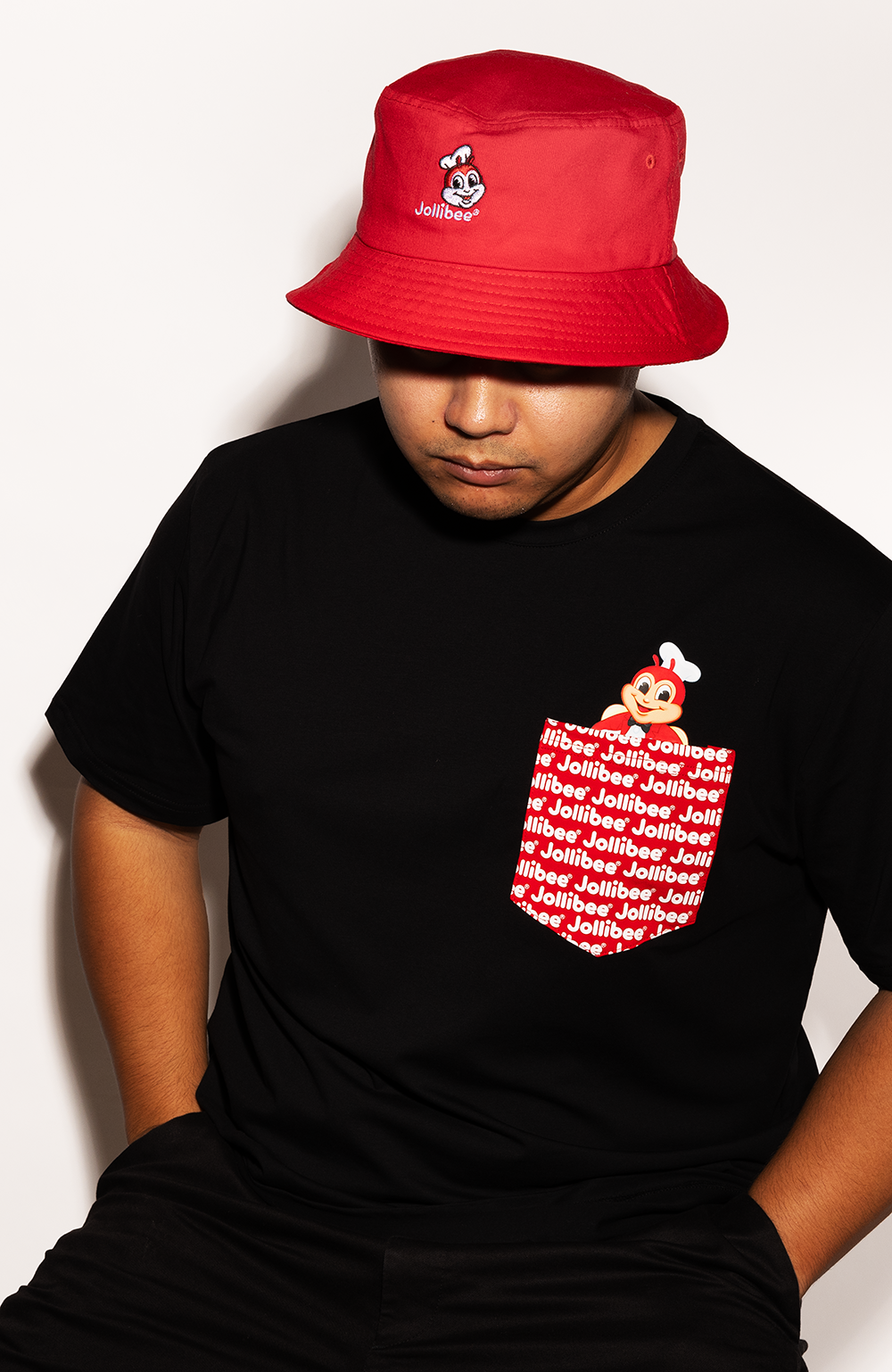 Mikey wearing the Jollibee black pocket tee and red bucket hat