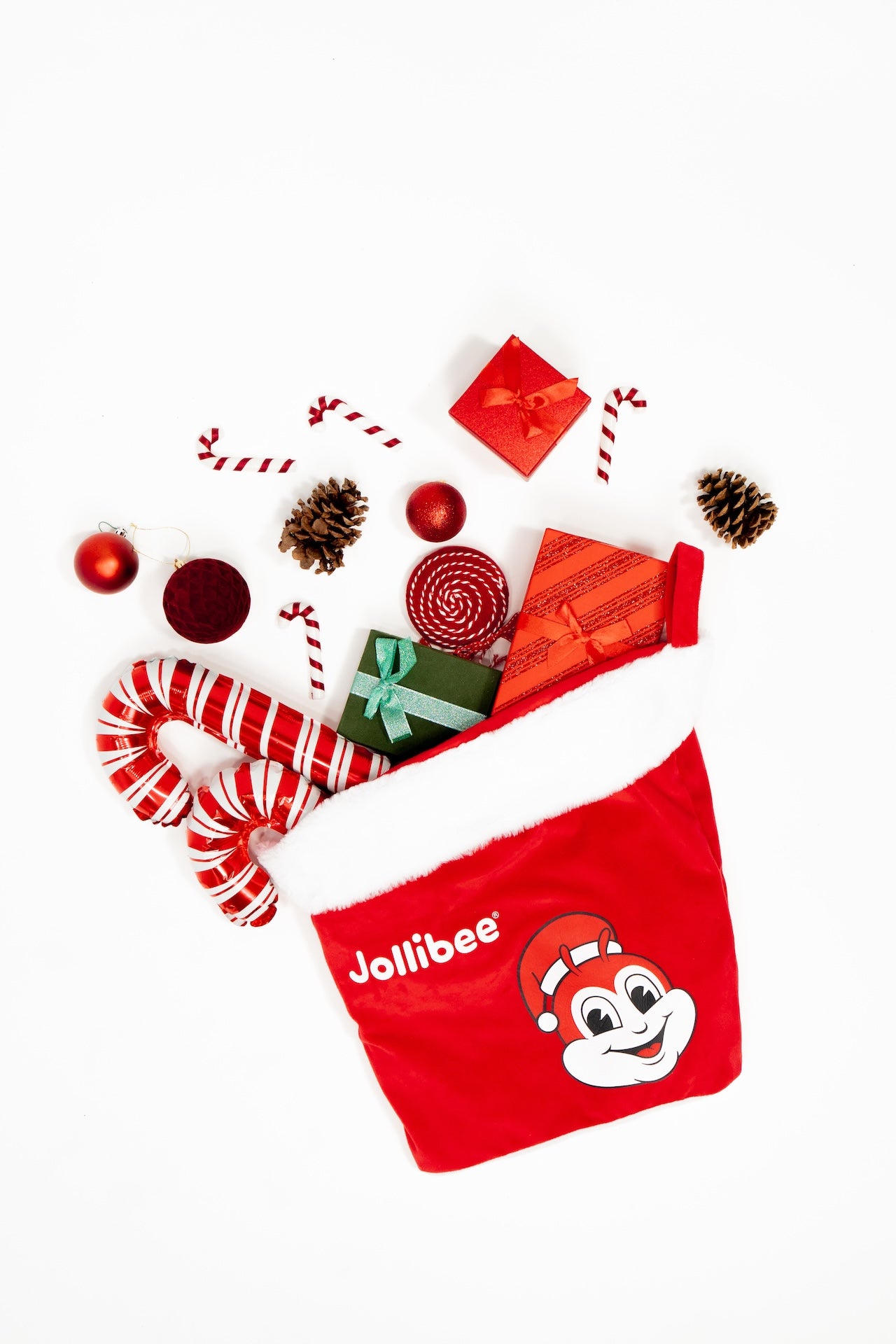 Red Jollibee branded Christmas stocking with Christmas-themed items on a white background