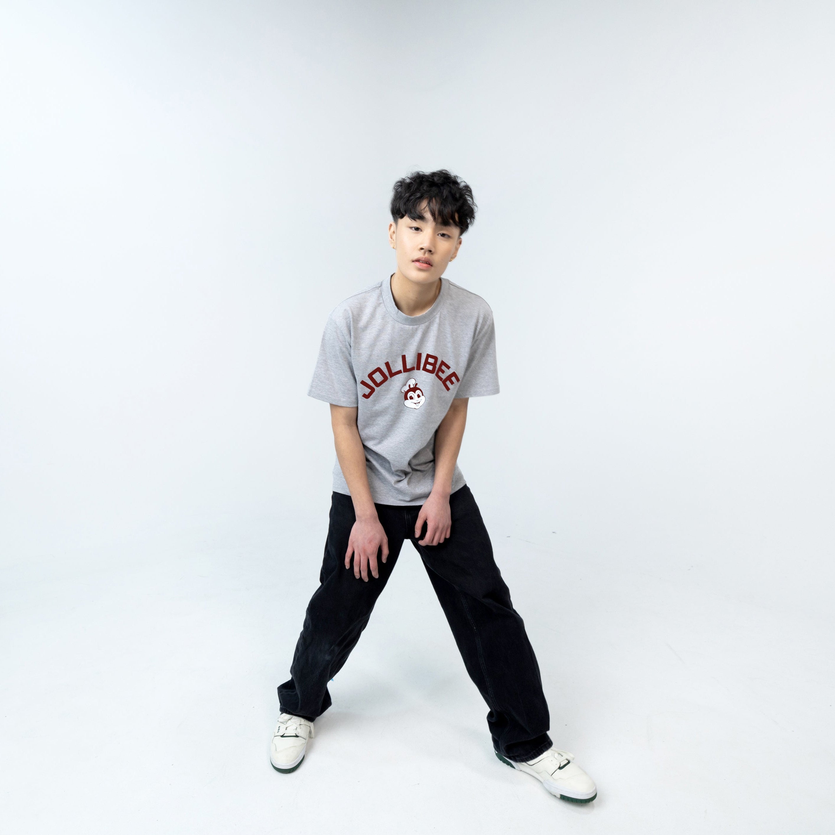 Person wearing a gray t-shirt and black pants on a white background