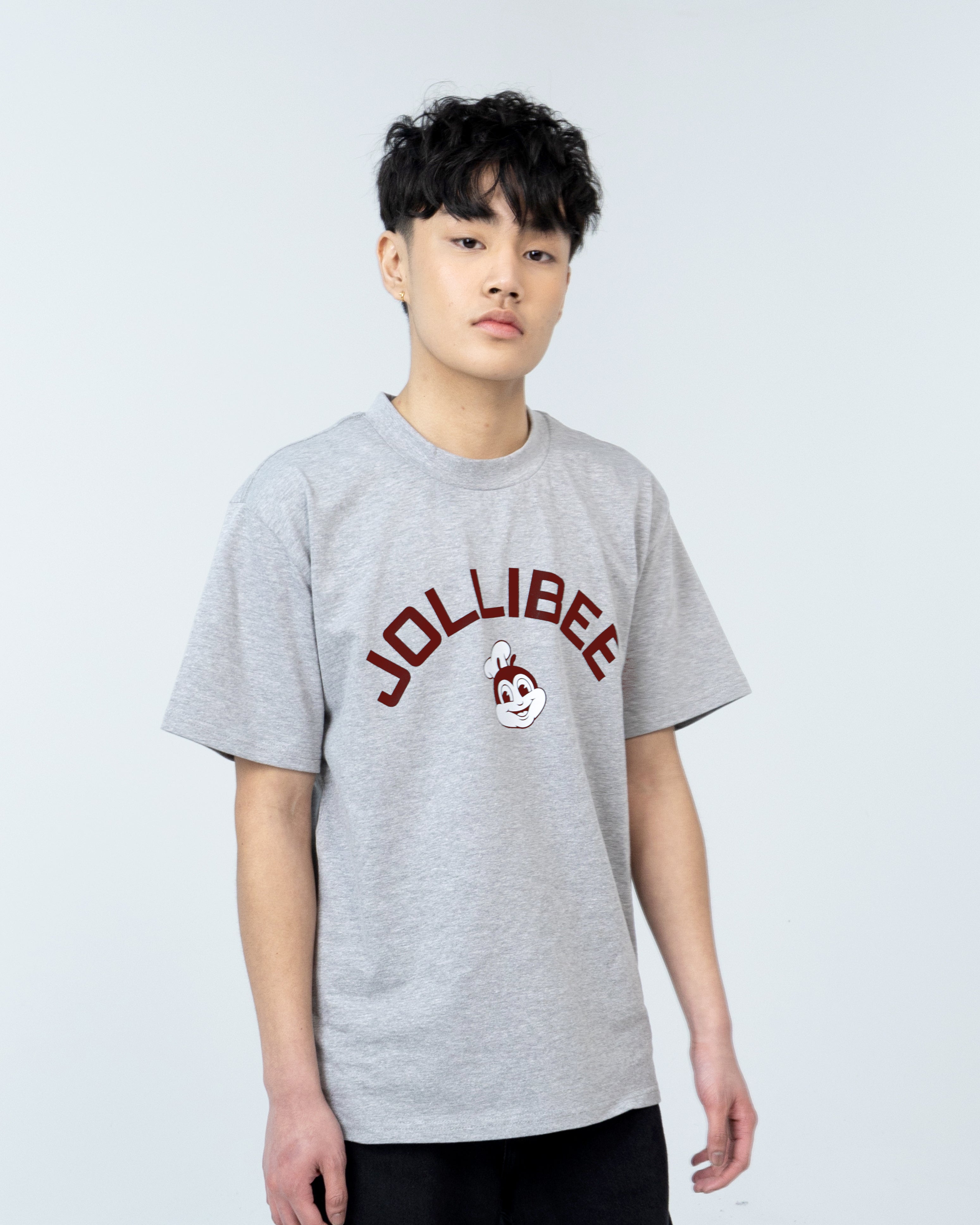 Guy wearing a gray shirt with the Jollibee logo printed on it.