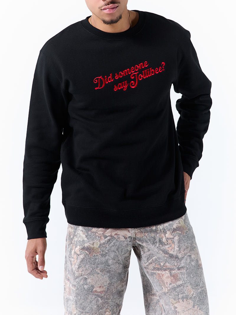 A young man wearing a black crewneck sweatshirt with a 'Did someone say Jollibee?' text across the chest on a white background.