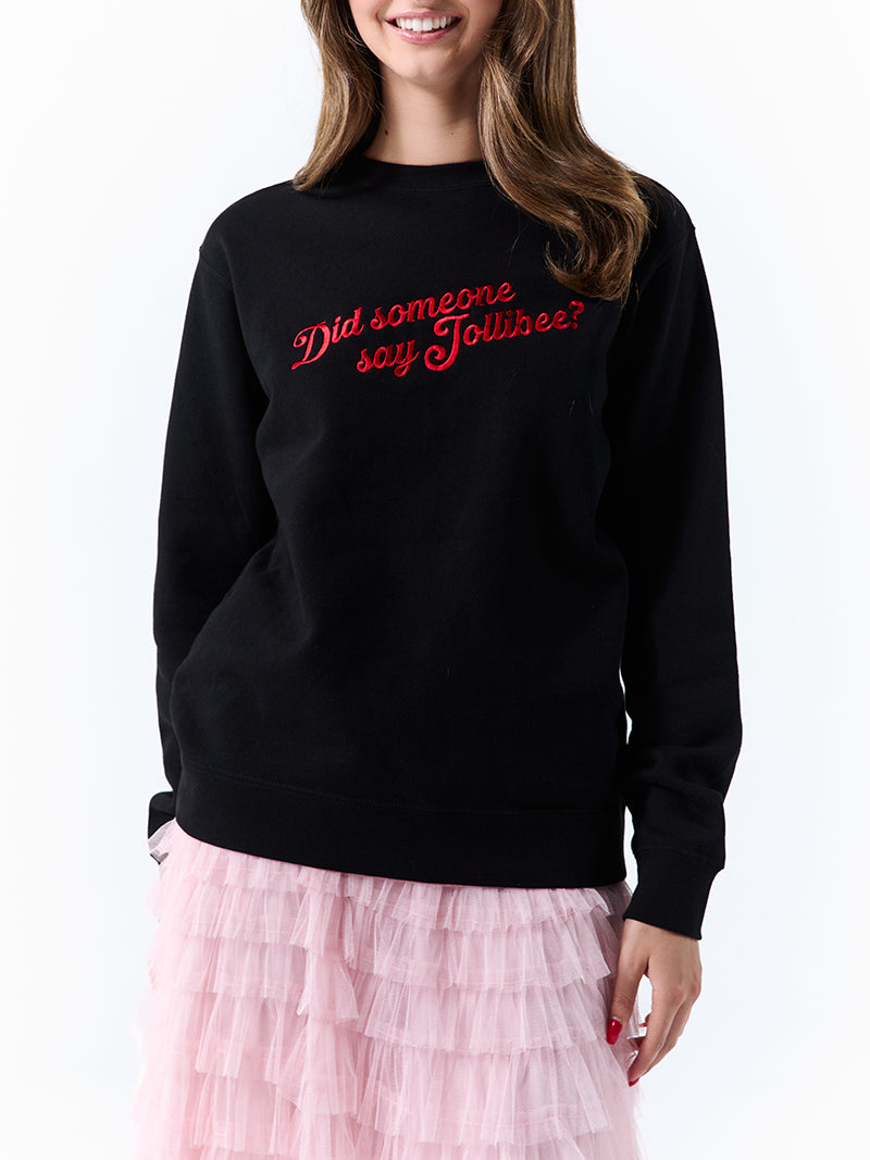 A young woman wearing a black crewneck sweatshirt with a 'Did someone say Jollibee?' text across the chest on a white background.