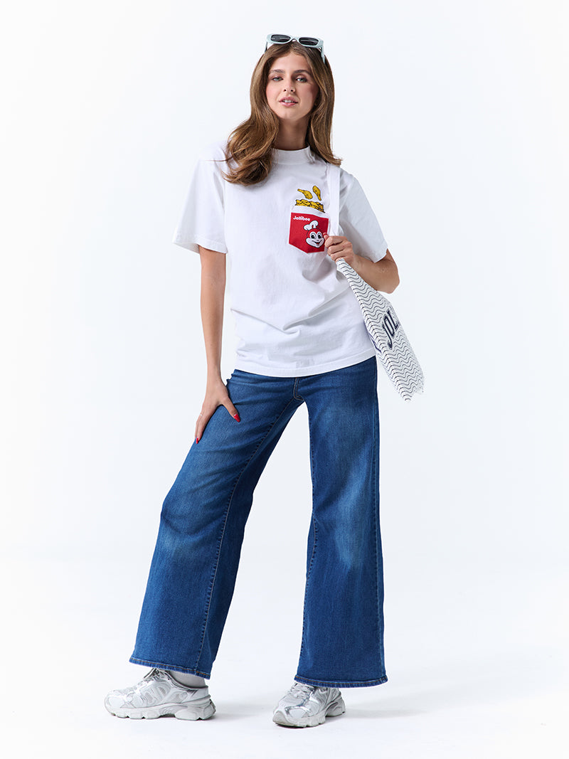 A young woman wearing a white t-shirt with a red pocket on the left chest, with a Jollibee logo and fried chicken design, holding a tote bag on a white background.