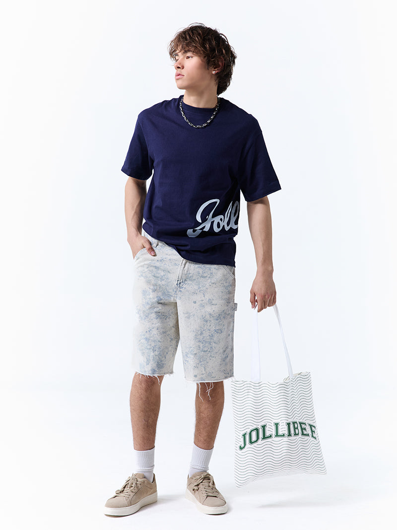 A young man wearing a navy t-shirt with 'Jollibee' in script on the side on a white background.