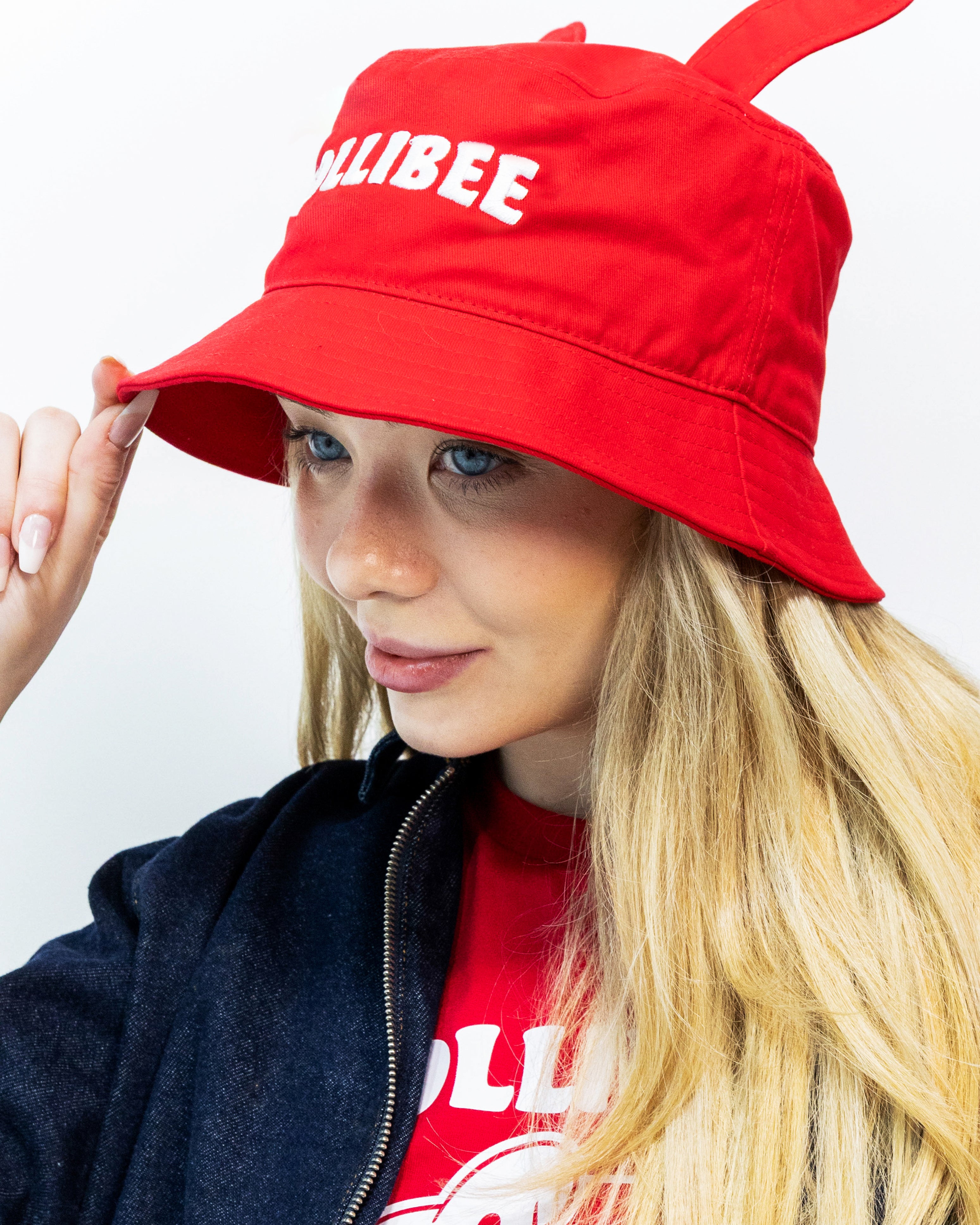 Person wearing a red bucket hat with 'JOLLIBEE' branding on a white background