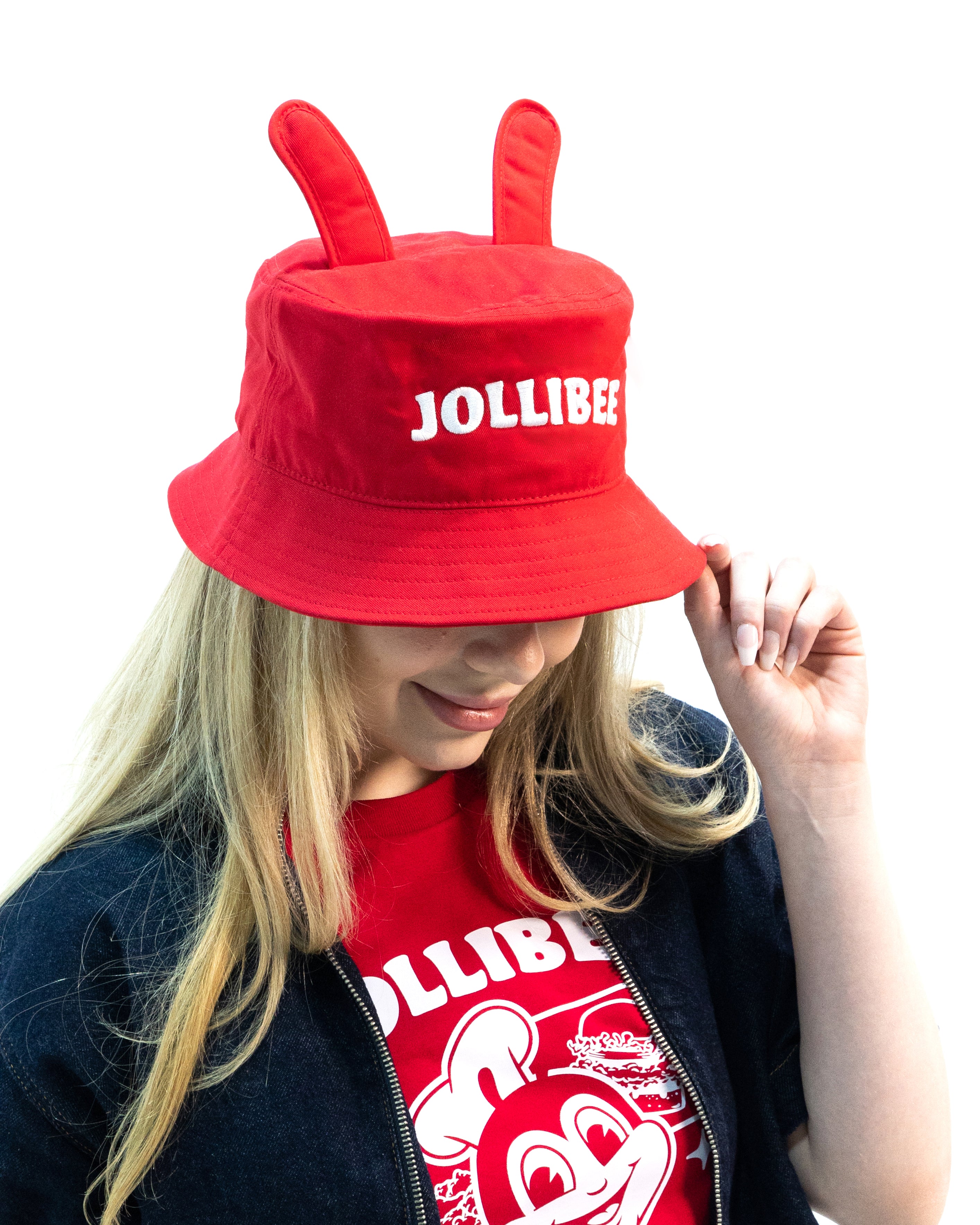 Person wearing a red Jollibee hat and shirt with a white background