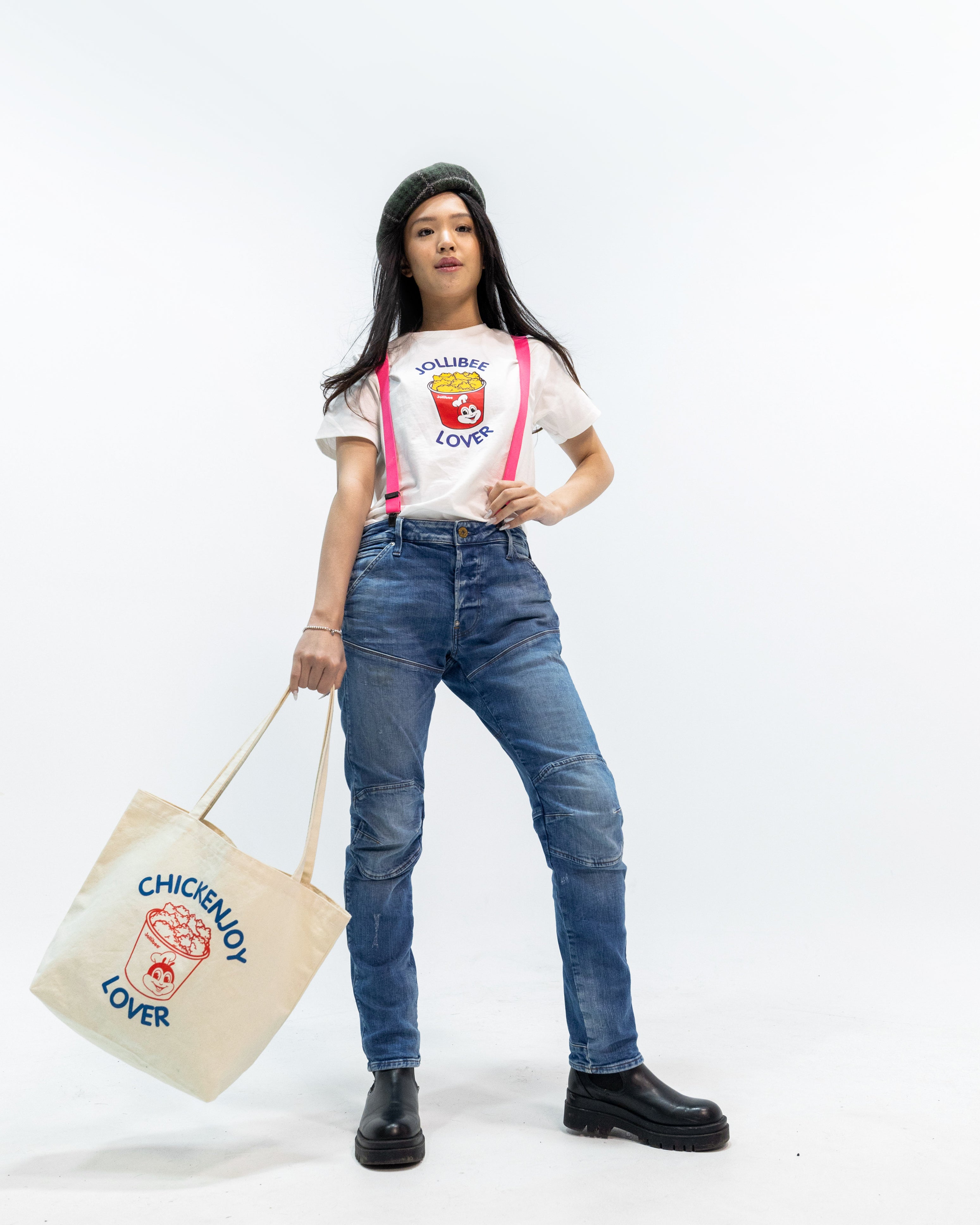 Person wearing a graphic t-shirt and jeans, holding a tote bag with 'Chickenjoy Lover' text.
