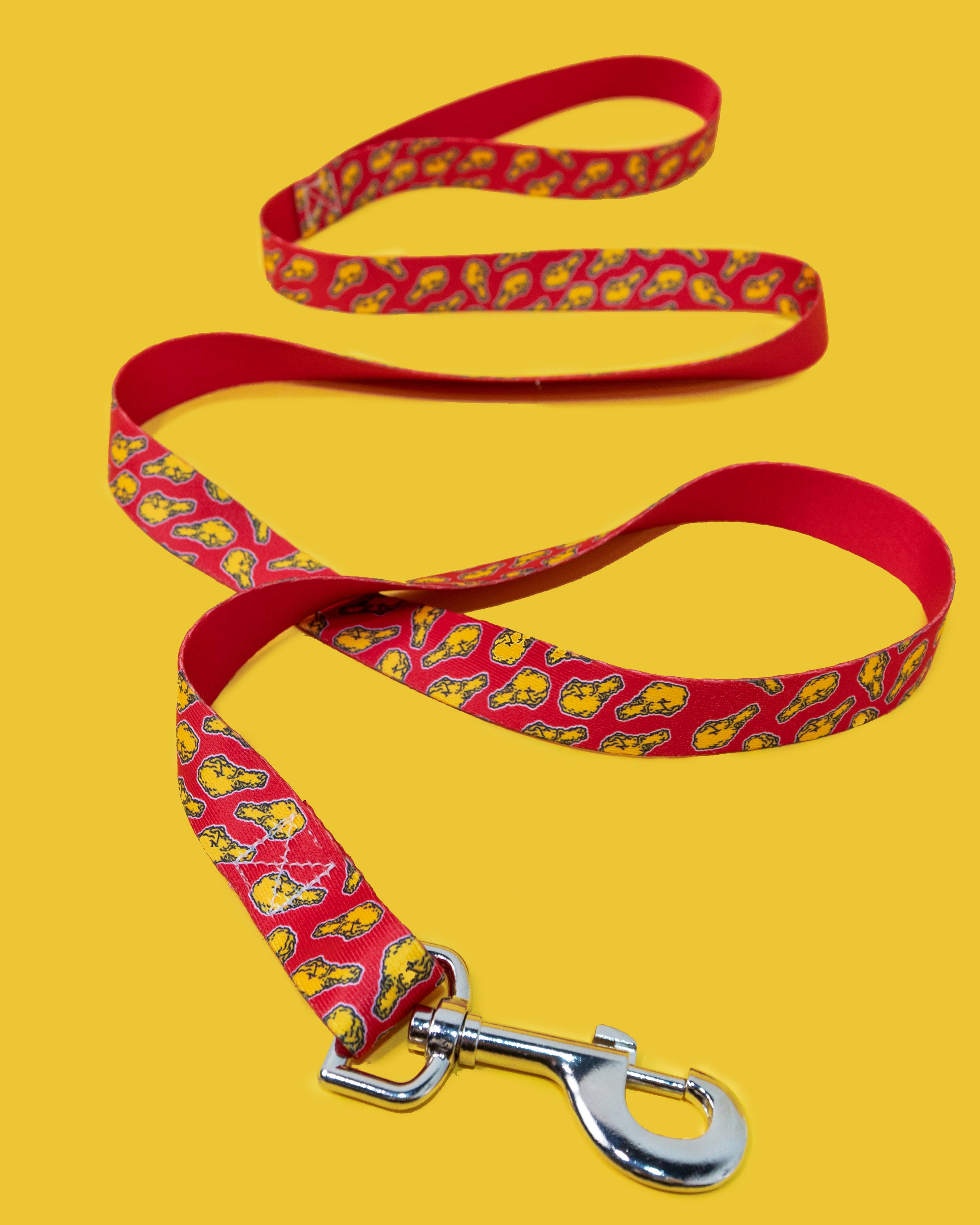 Red dog leash with yellow pattern on a yellow background