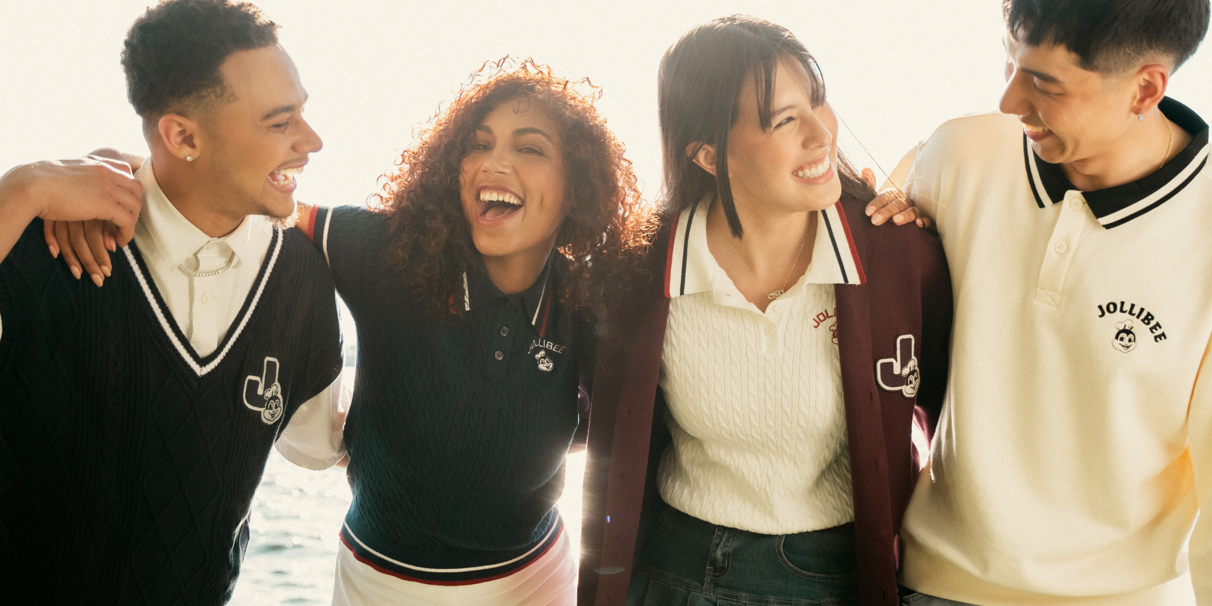 A group of friends laughing and smiling while wearing Jollibee merch.