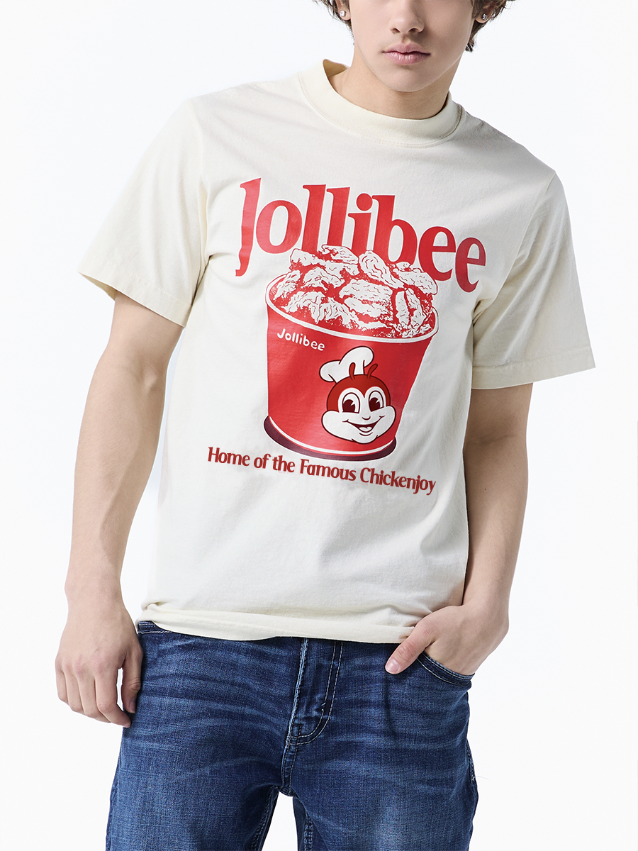 Person wearing a beige t-shirt with Jollibee logo and text