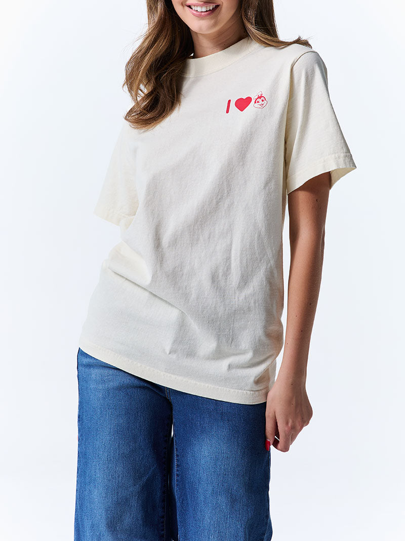 Person wearing a white t-shirt with a red graphic design on a plain background