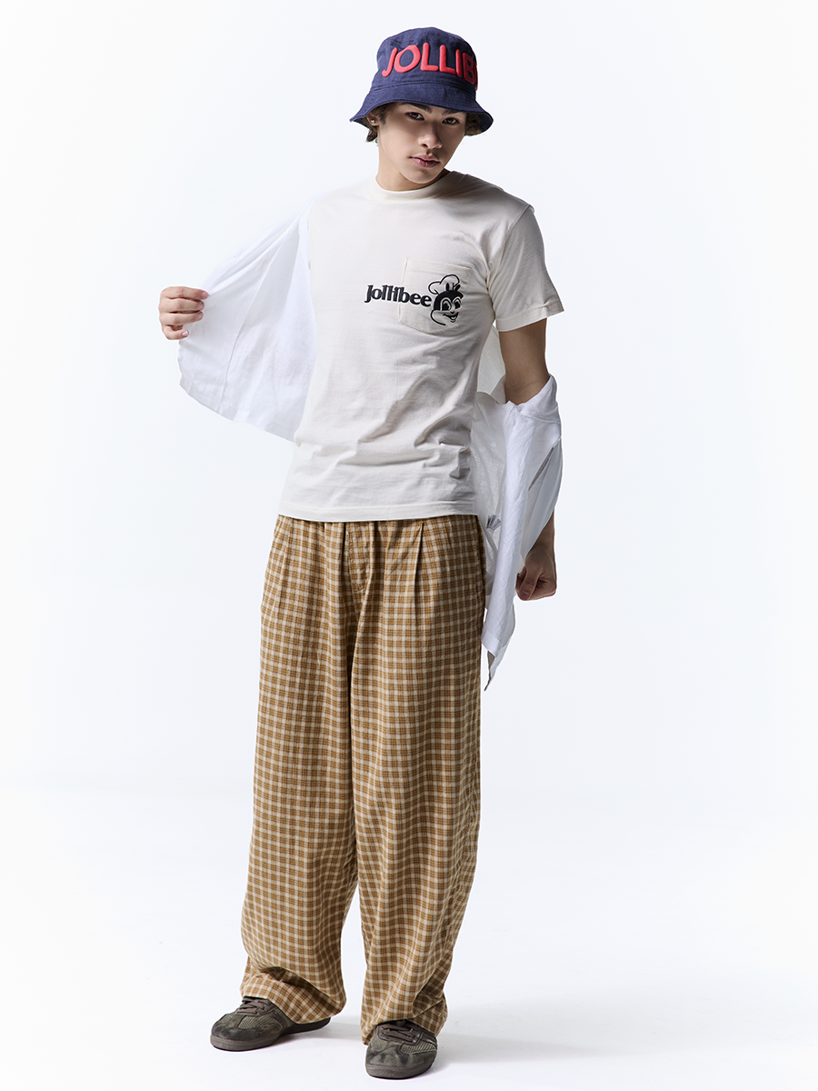 Person wearing a white t-shirt with a logo, plaid pants, and a bucket hat on a white background