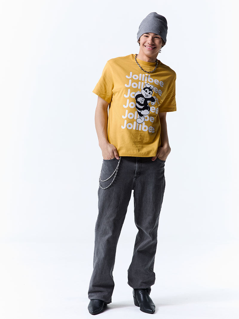 Person wearing a yellow t-shirt with text and graphics, dark pants, and a gray beanie on a white background