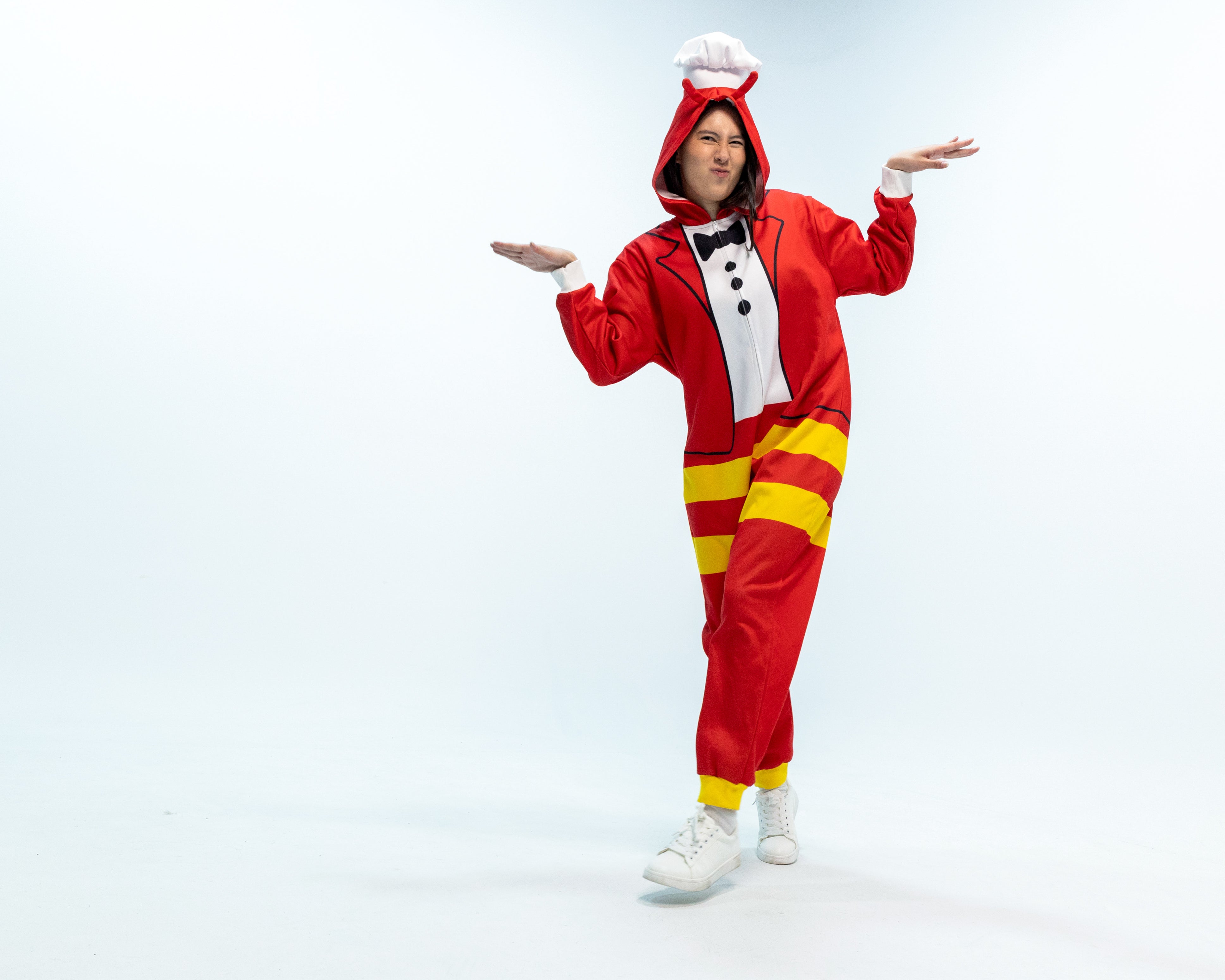 Person wearing a Jollibee red and yellow onesie on a white background