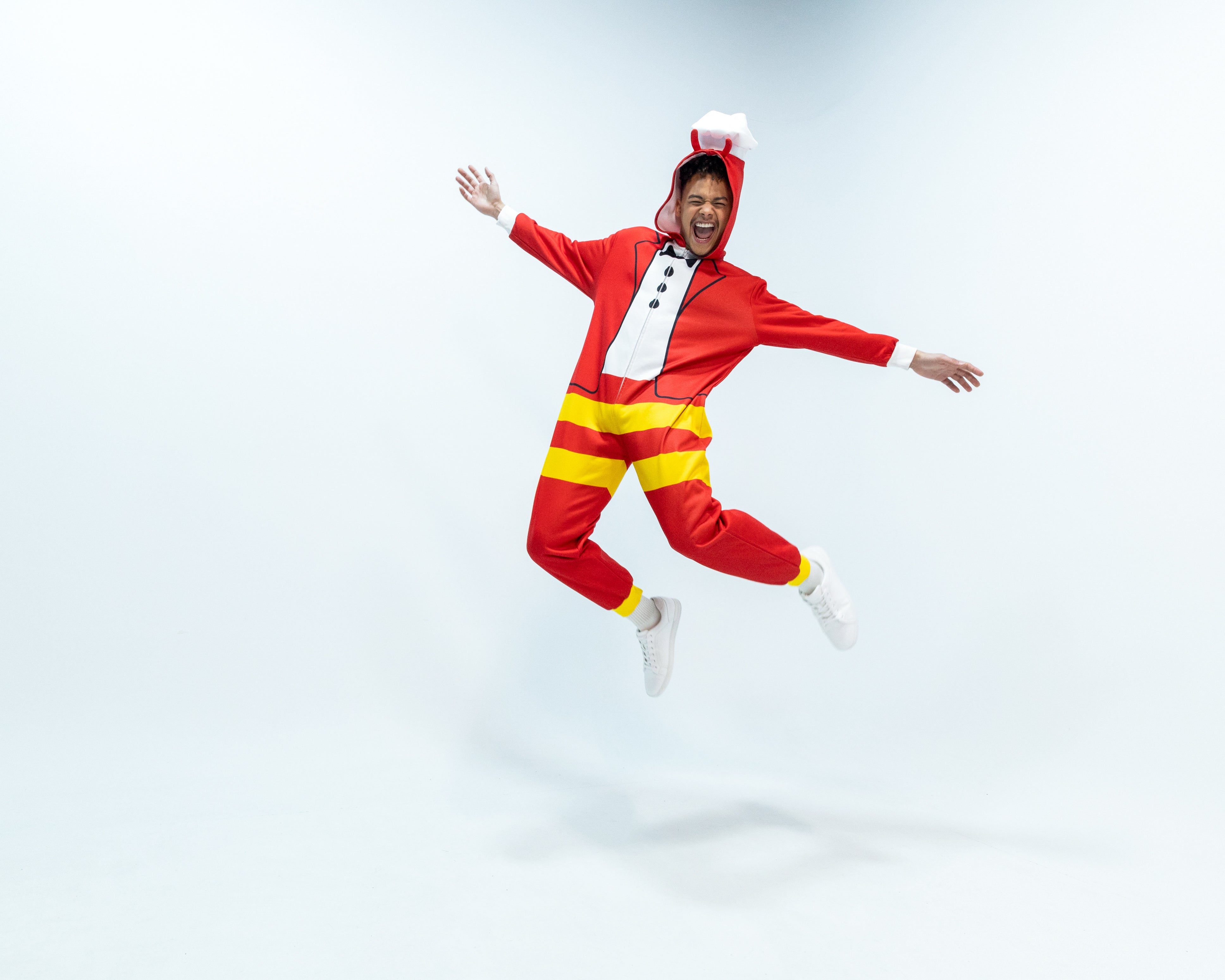 Person wearing a Jollibee red and yellow onesie on a white background