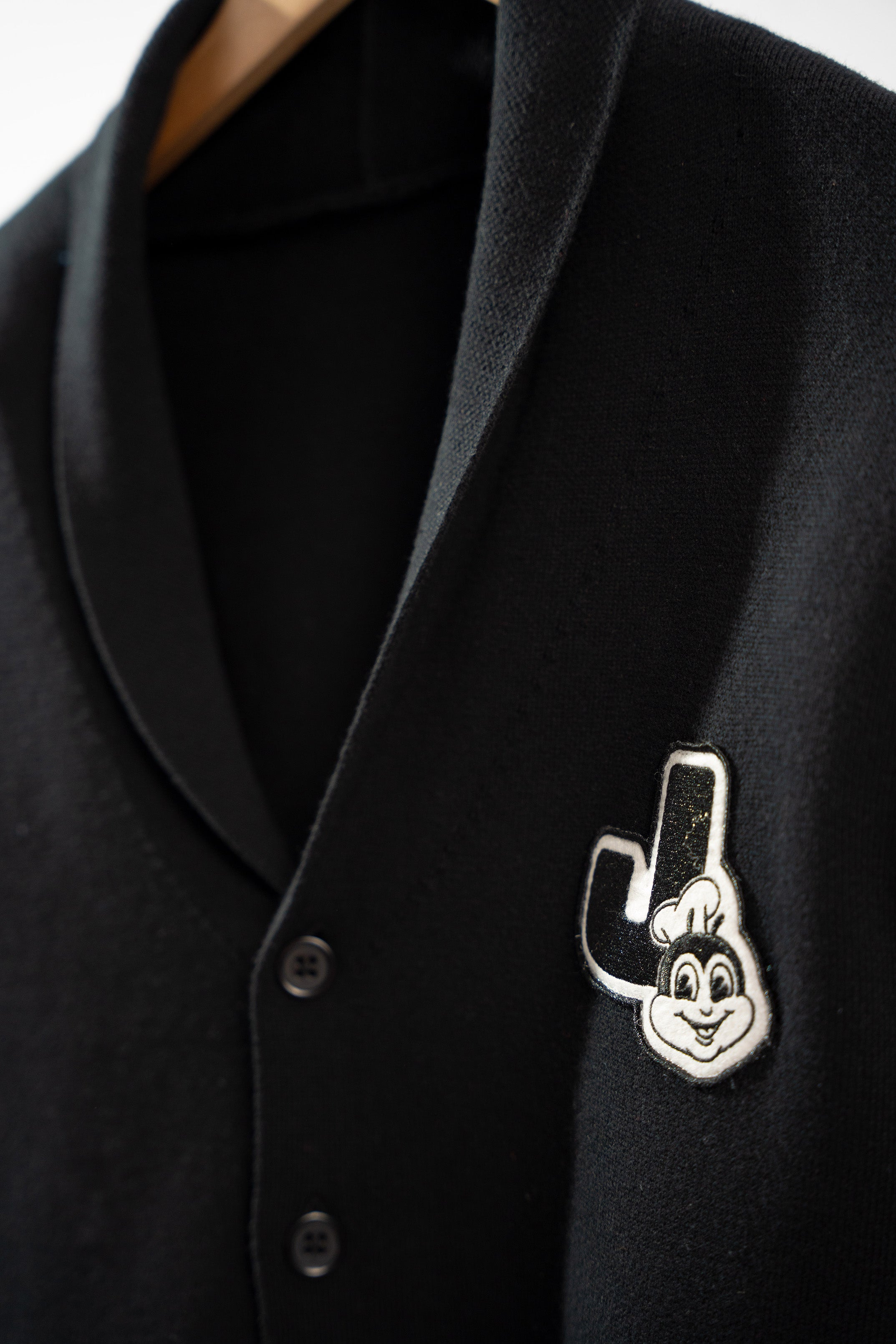 Black cardigan with a Jollibee logo on a white background