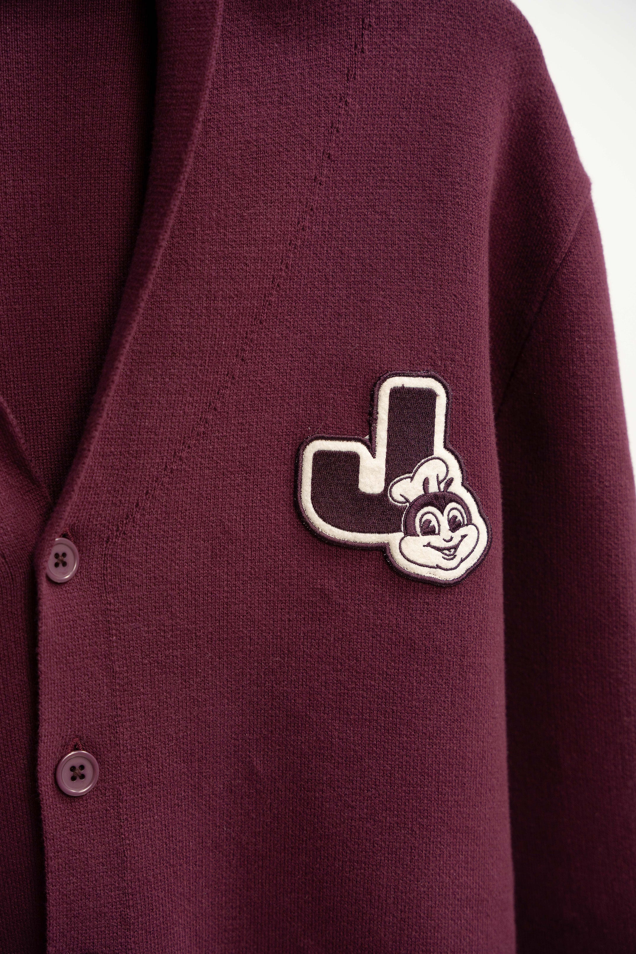 Maroon cardigan with a Jollibee logo patch on a white background
