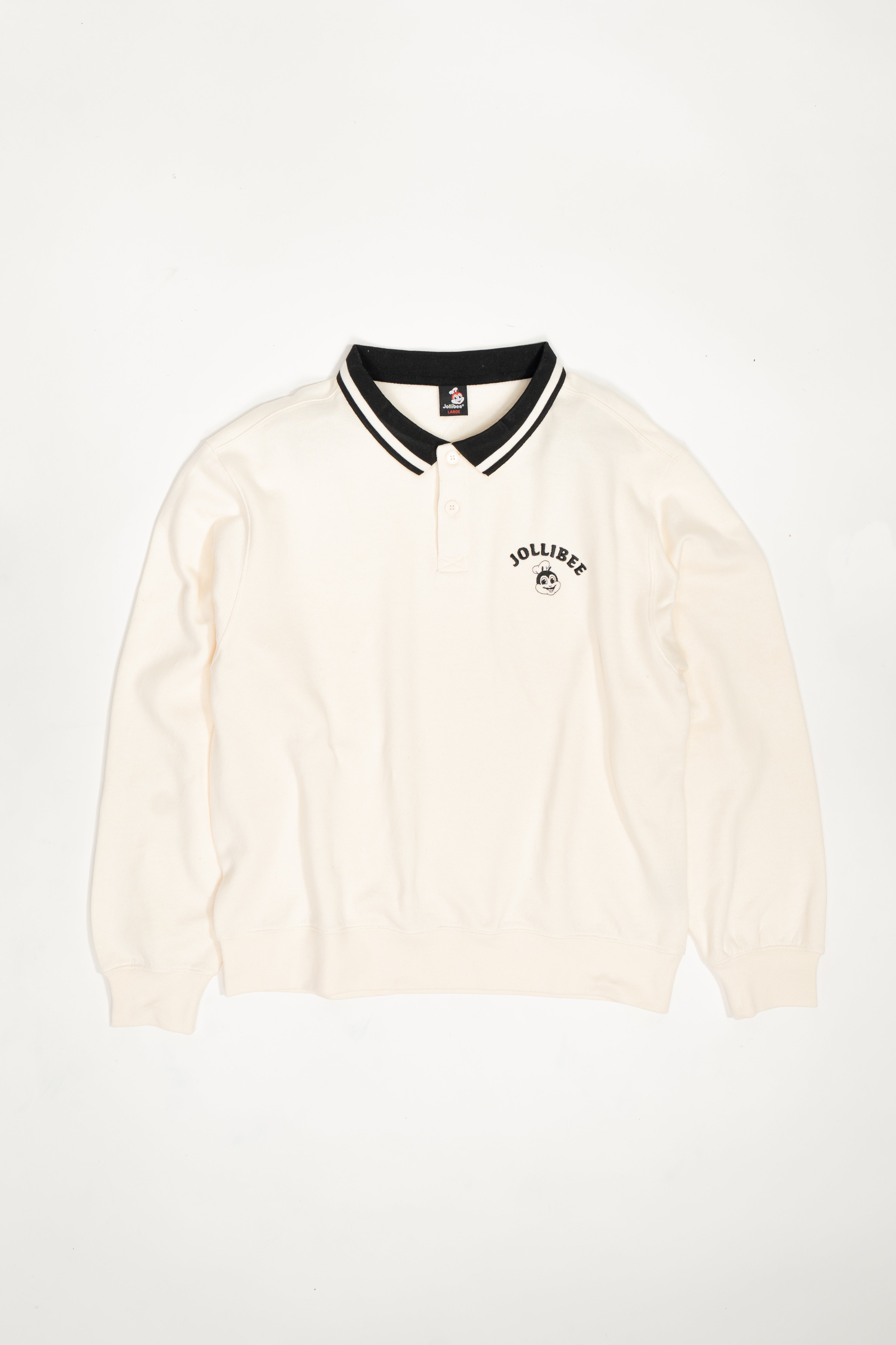 Cream-colored polo shirt with black collar on a white background