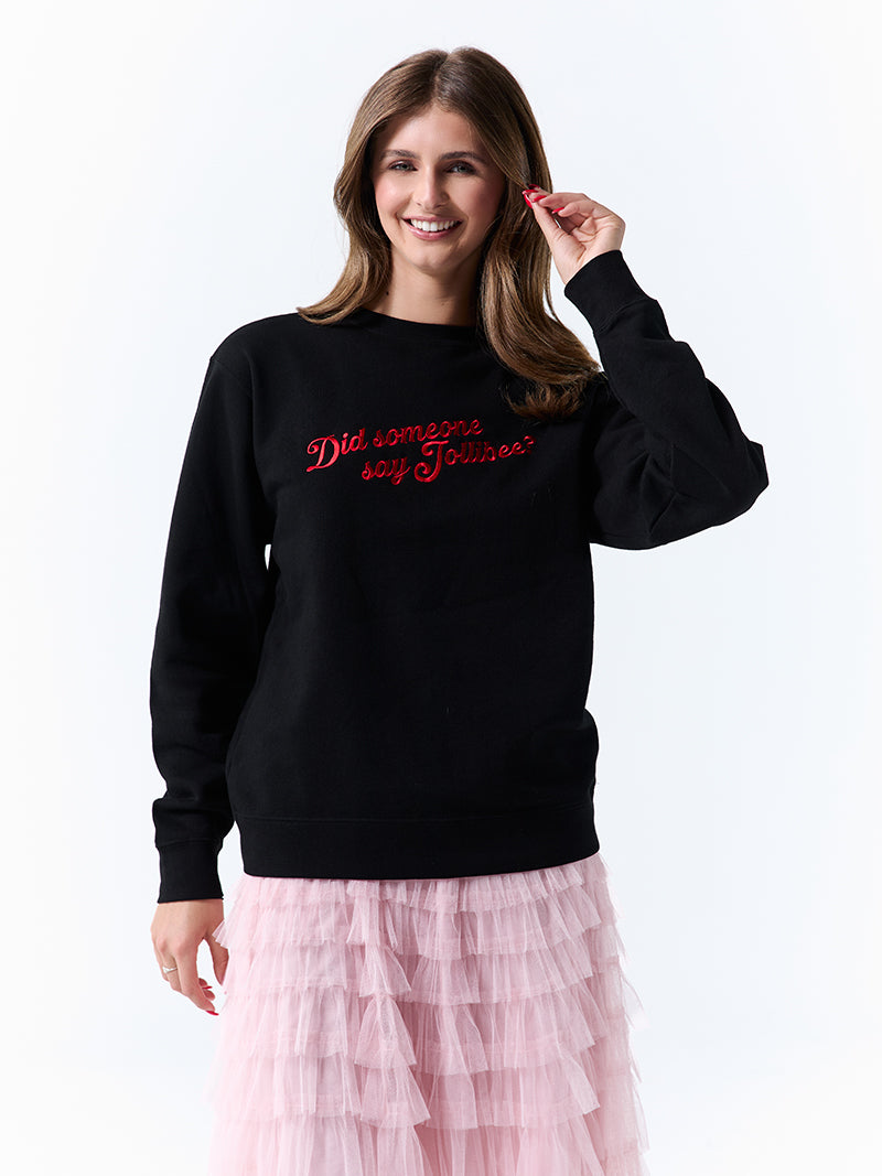 A young woman wearing a black crewneck sweatshirt with a 'Did someone say Jollibee?' text across the chest on a white background.