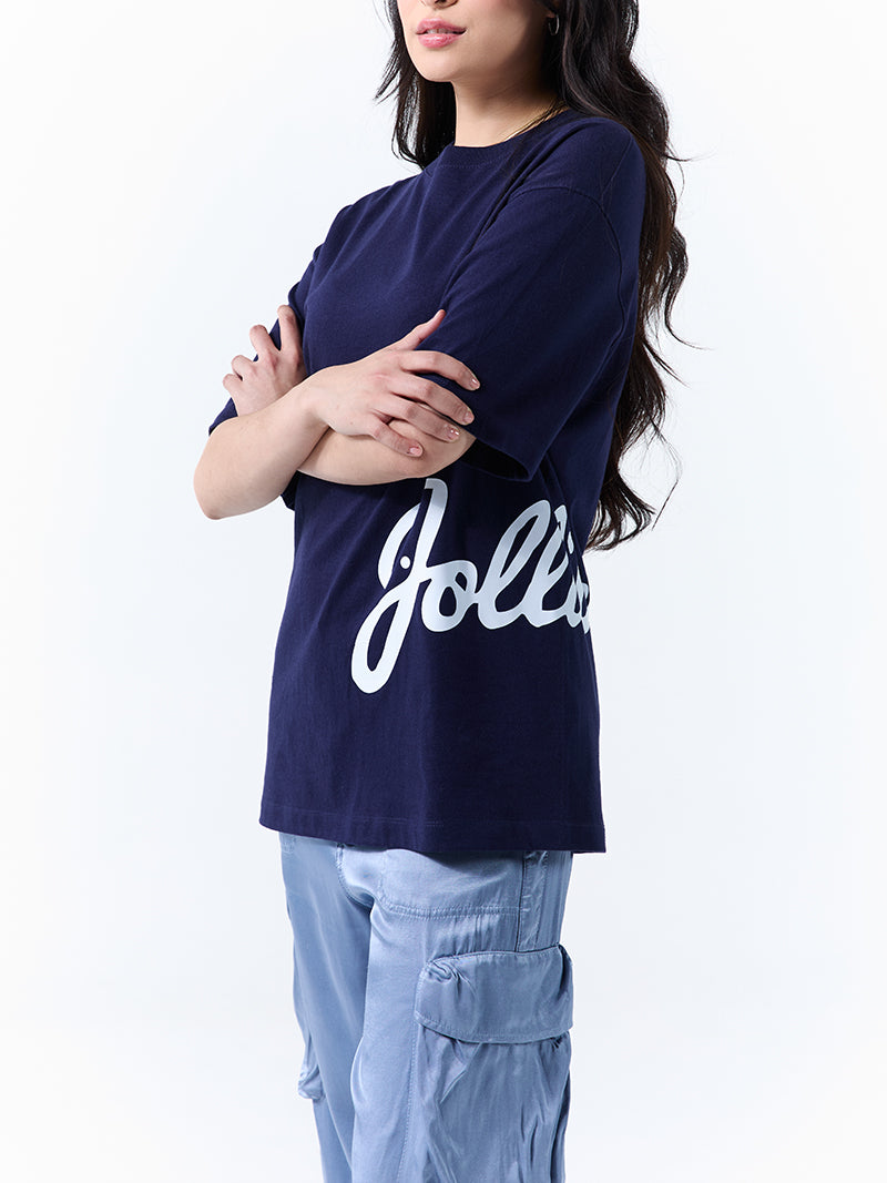 A young woman wearing a navy t-shirt with 'Jollibee' in script on the side on a white background.