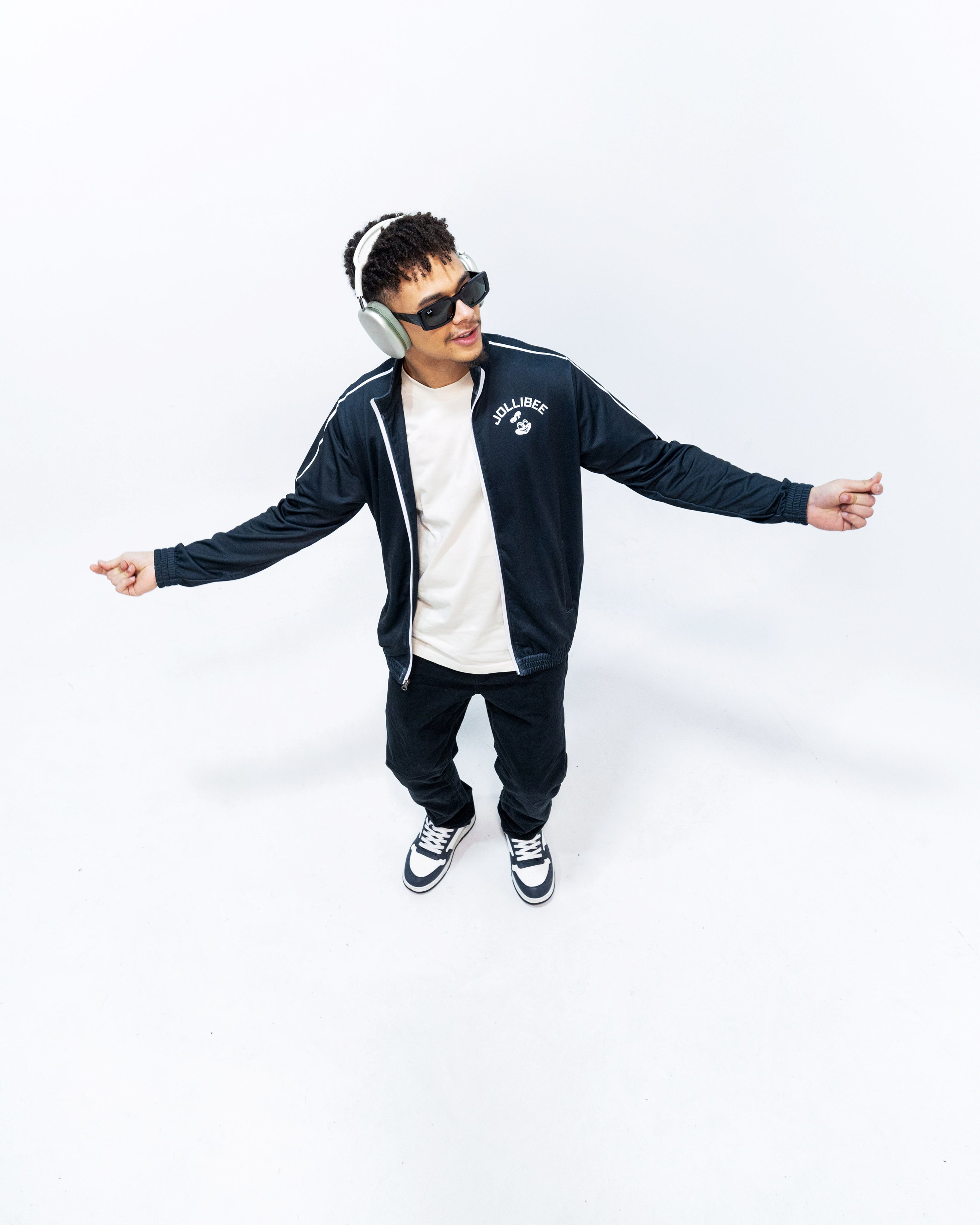 guy standing wearing Jollibee merch black tracksuit jacket
