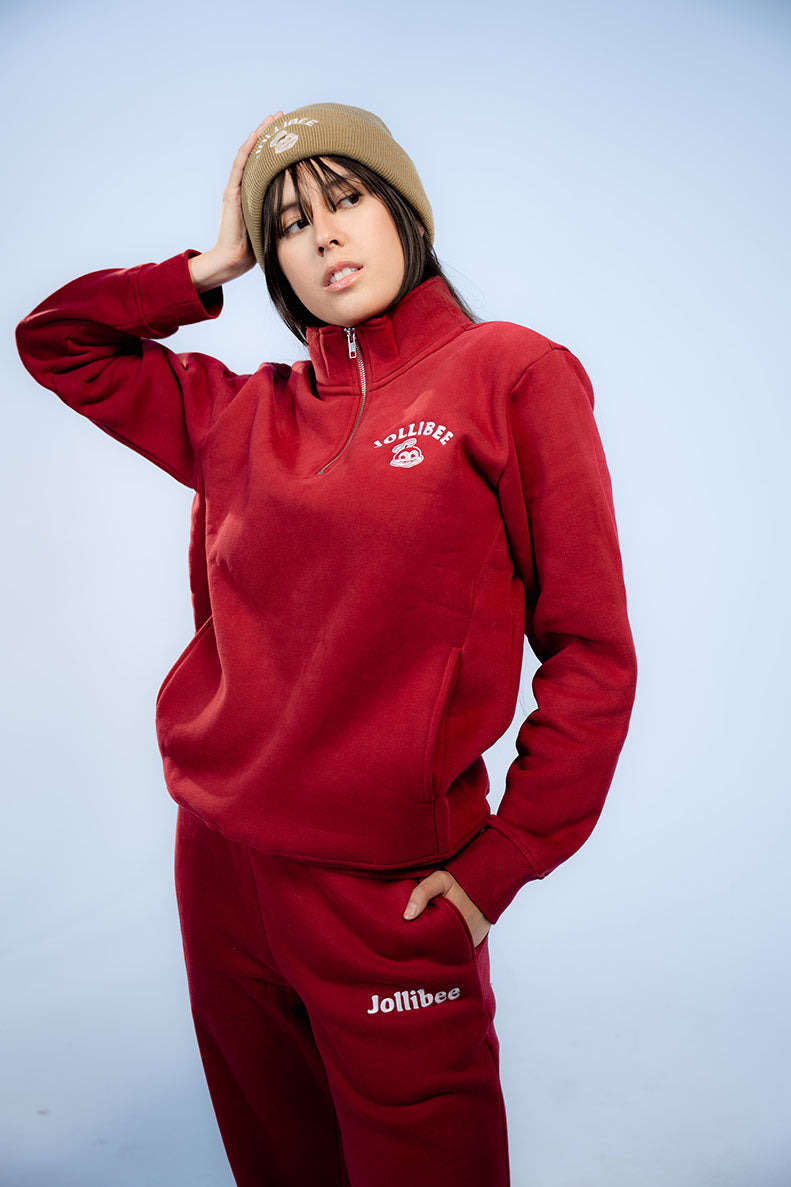 Person wearing a red Jollibee tracksuit against a light blue background