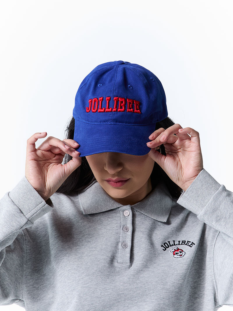 Person wearing a blue cap with 'Jollibee' branding and a matching polo shirt.