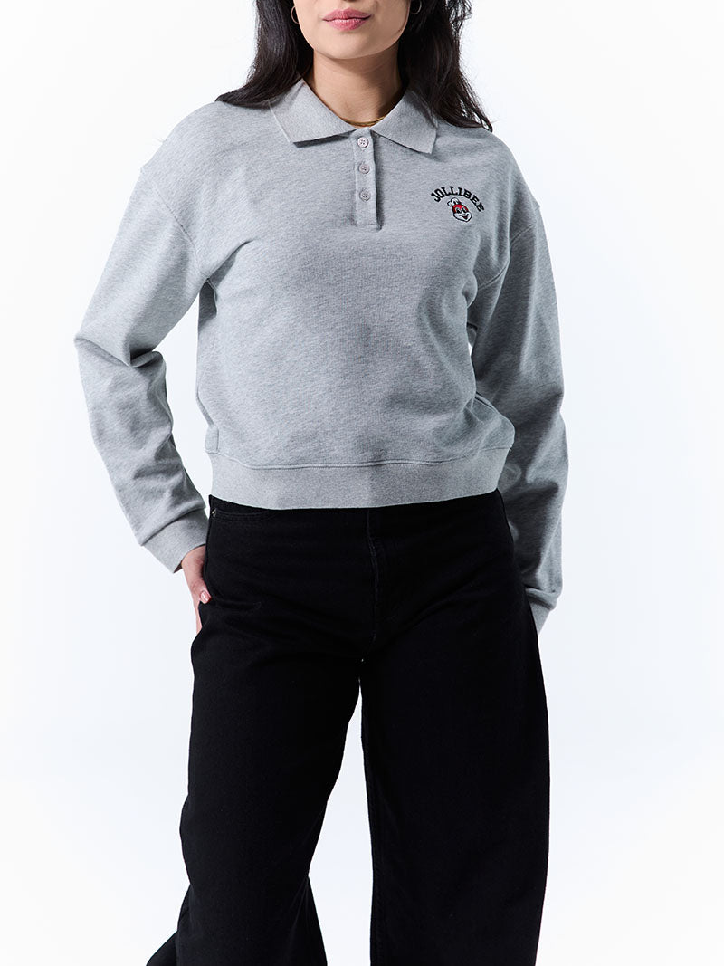 Person wearing a gray sweatshirt with a logo on a white background