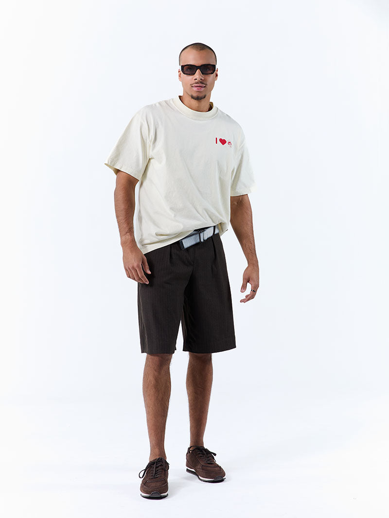 Man wearing a white t-shirt with a graphic design, black shorts, and sunglasses on a white background
