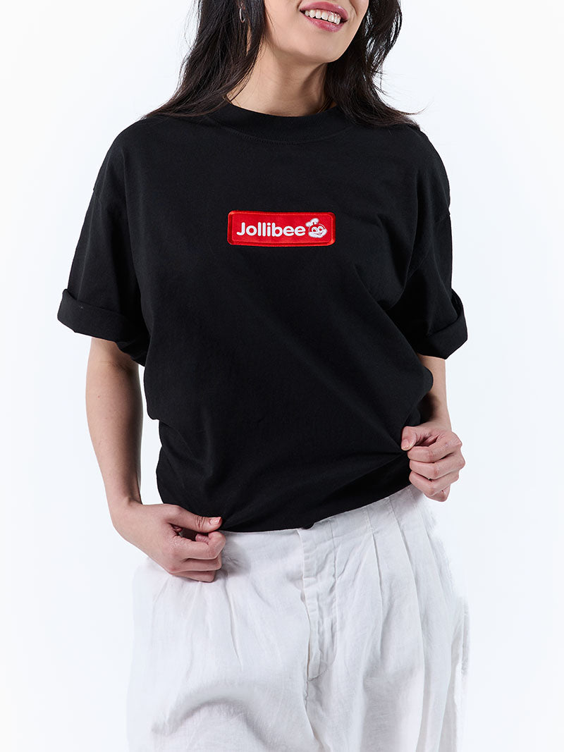 Person wearing a black t-shirt with Jollibee logo on a white background