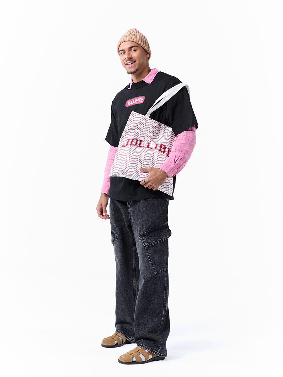 Person wearing a black and pink t-shirt with 'Jollibee' branding and a tote bag on a white background