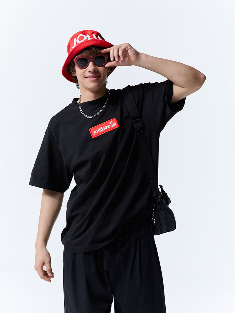 Person wearing a black t-shirt with a red logo, dark pants, and a red bucket hat on a white background.