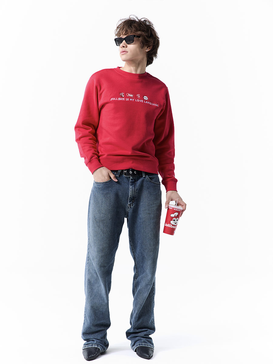 Person wearing a red sweatshirt and blue jeans holding a red cup on a white background