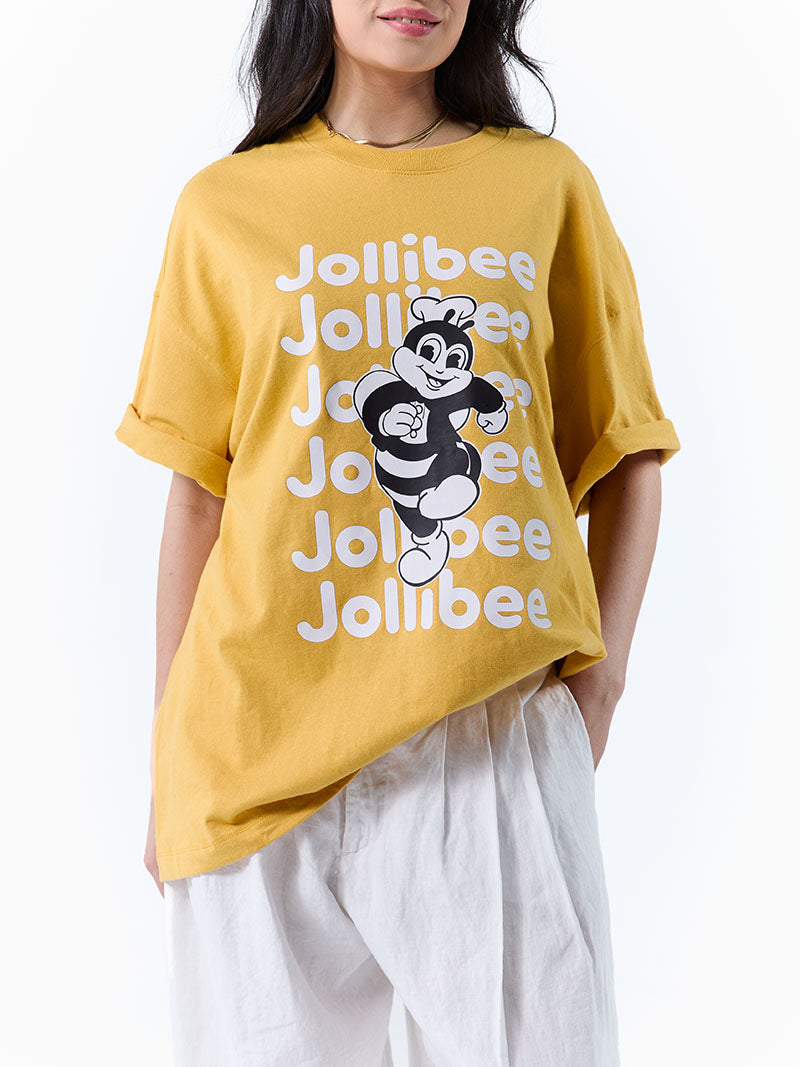 Person wearing a mustard yellow Jollibee t-shirt on a white background