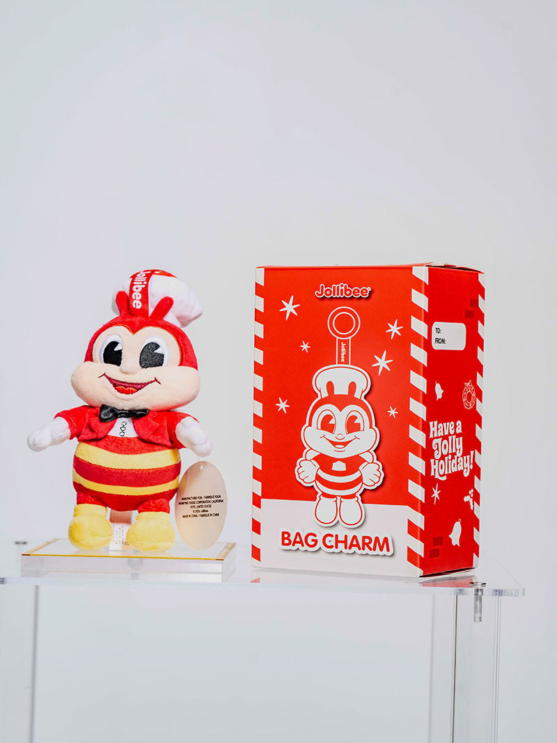 Jollibee Charm on top of a glass case and the box the charm comes in. 