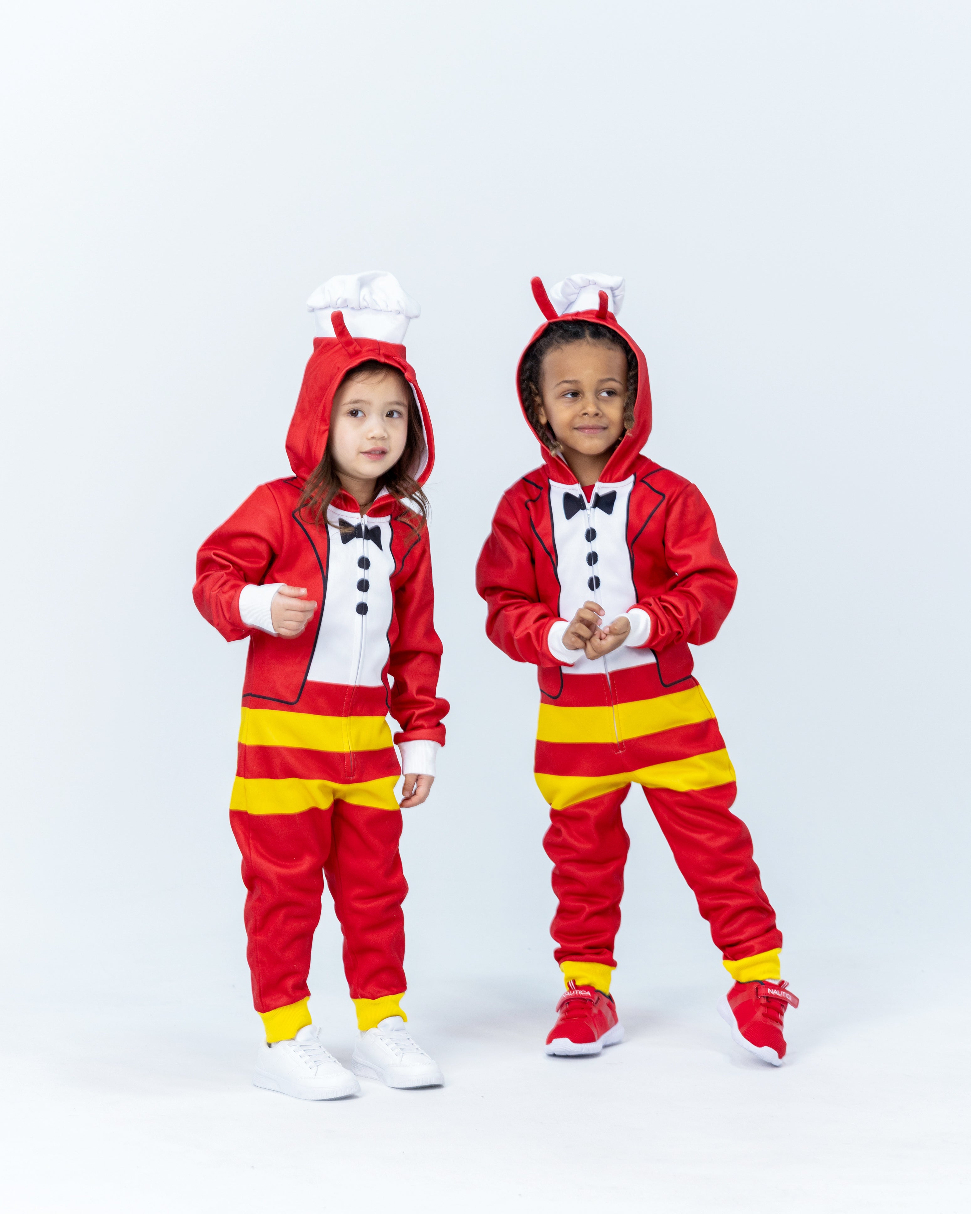Two children wearing Jollibee red and yellow onesies on a white background